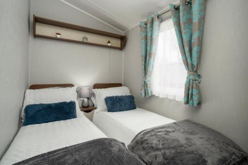 Port Seton的住宿－Seton Sands-3 Bed Static Caravan，带窗户的客房内设有两张单人床。