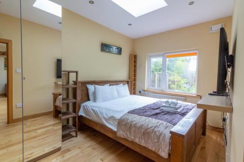 1 dormitorio con cama, ventana y TV en GuestReady - Glasnevin Charm near DCU, en Dublín