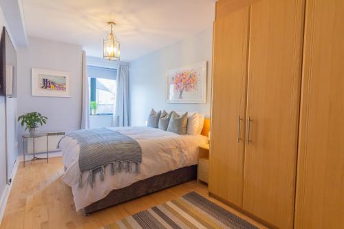 1 dormitorio con 1 cama y un gran armario de madera en GuestReady - Lively Apt near Dublin Castle, en Dublín