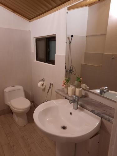 a white bathroom with a sink and a toilet at Bhurban Valley Cottages 3 in Bhurban