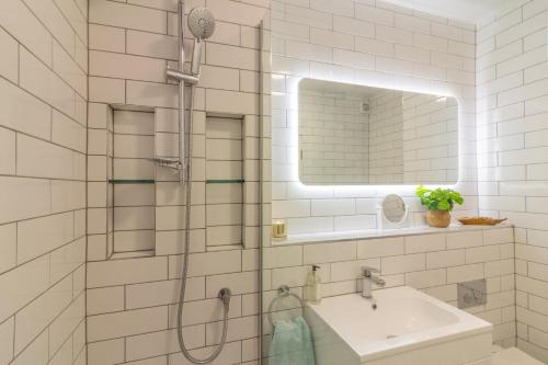 a bathroom with a shower with a sink and a mirror at GuestReady - Lively Apt near Dublin Castle in Dublin