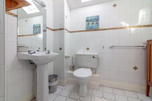 biała łazienka z toaletą i umywalką w obiekcie GuestReady - Castle Proximity and Modern Charm w Dublinie