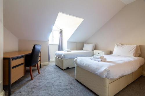 um quarto com 2 camas e uma secretária. em GuestReady - Castle Proximity and Modern Charm em Dublin