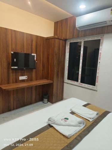 a room with a bed with a tv on the wall at Airport Hotel Relax Inn in Nagpur