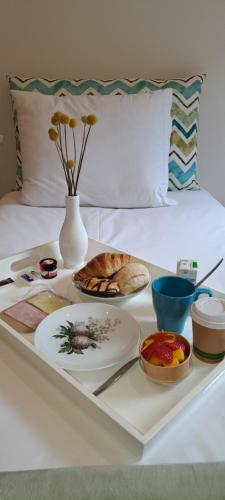 een dienblad met borden eten op een bed bij ALMARELA apartments in Porto