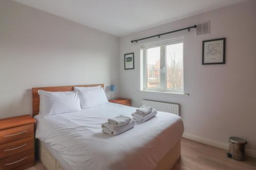 een slaapkamer met een bed met handdoeken erop bij GuestReady - Coastal Charm near Sandymount Beach in Dublin
