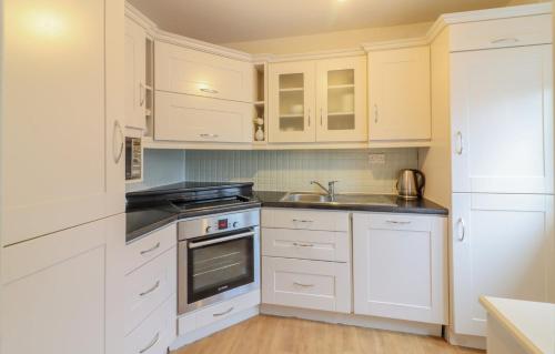 a kitchen with white cabinets and a sink at GuestReady - Coastal Charm near Sandymount Beach in Dublin