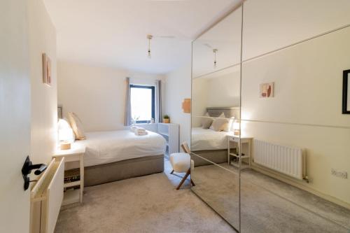 um quarto com um espelho, uma cama e uma cadeira em GuestReady - City Centre Bliss in Temple Bar em Dublin