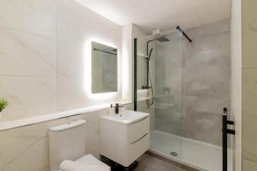 uma casa de banho branca com um WC e um chuveiro em GuestReady - City Centre Bliss in Temple Bar em Dublin