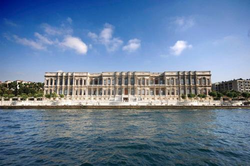 ein großes Gebäude auf dem Wasser vor einem Gebäude in der Unterkunft Çırağan Palace Kempinski Istanbul in Istanbul