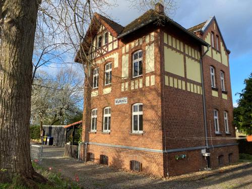 an old brick building on the side of a tree at Bahnhof Mulknitz in Forst