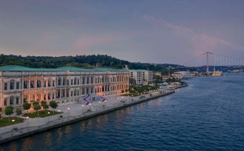 un grand bâtiment à côté de l'eau avec un pont dans l'établissement Çırağan Palace Kempinski Istanbul, à Istanbul
