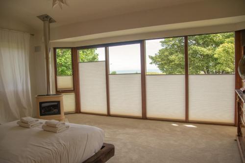 a bedroom with windows and a bed with towels on it at GuestReady - Epitome of Luxury near Shankill Beach in Dublin