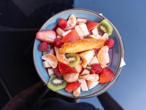a bowl of fruit with strawberries kiwis and oranges at Kyriad Lyon Sud Sainte Foy in Sainte-Foy-lès-Lyon
