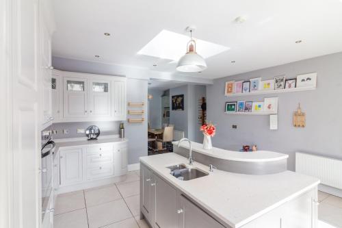 a kitchen with white cabinets and a sink at GuestReady - Restful stay in Drimnagh in Crumlin