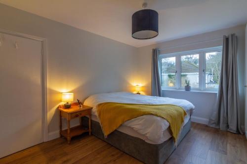 ein Schlafzimmer mit einem Bett, einem Fenster und zwei Lampen in der Unterkunft GuestReady - Serene Haven near Castle Golf Club in Dublin