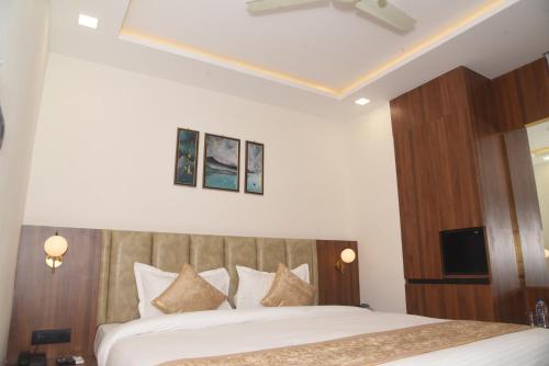 um quarto com uma grande cama branca e uma cabeceira em madeira em HOTEL LAWANG SIGNAGE em Deoghar