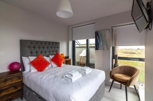 um quarto com uma cama com almofadas vermelhas e uma cadeira em GuestReady - Tranquil Slumber in The Coast em Dublin