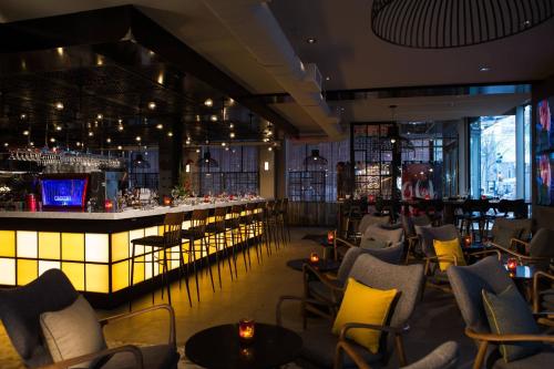 a bar at a restaurant with yellow chairs and tables at Renaissance Montreal Downtown Hotel in Montréal