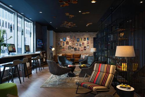 a lobby with chairs and a bar in a building at Renaissance Montreal Downtown Hotel in Montréal