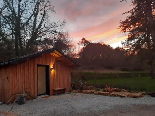 a wooden shed with a sunset in the background at Le chalet Graines d'Amour in Grand-Champ