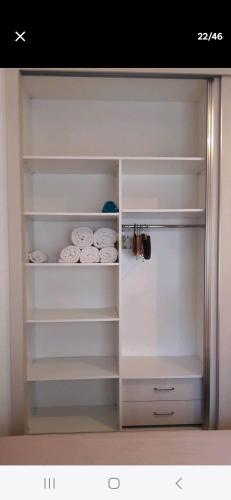a closet with white shelves and white plates at Anaelle in Birmandreis