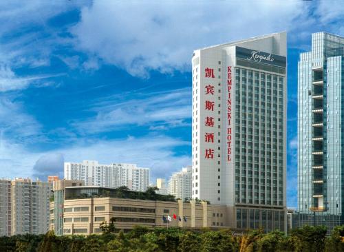 ein hohes Gebäude mit einem Schild an der Seite in der Unterkunft Kempinski Hotel Shenzhen - 24 Hours Stay Privilege, Subject to Hotel Inventory in Shenzhen