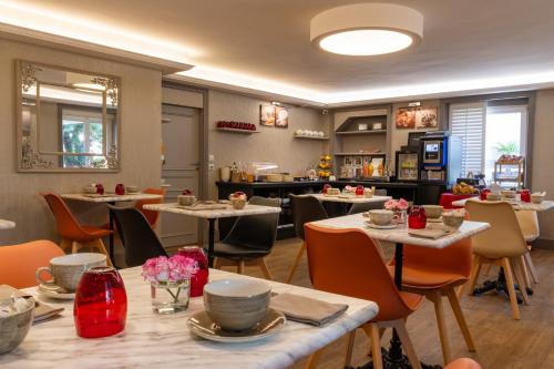 un restaurant avec des tables et des chaises et une cuisine dans l'établissement Hôtel La Villefromoy, à Saint-Malo