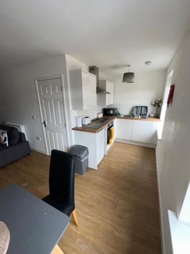 een keuken met witte kasten en een tafel in een kamer bij Riverside Relax 1 bedroom near Airport and City Centre PL in Liverpool