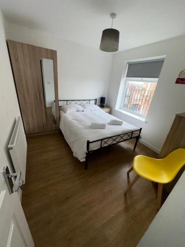 a bedroom with a bed and a yellow chair at Riverside Relax 1 bedroom near Airport and City Centre PL in Liverpool