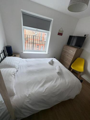 ein Schlafzimmer mit einem großen weißen Bett und einem Fenster in der Unterkunft Riverside Relax 1 bedroom near Airport and City Centre PL in Liverpool