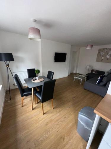 ein Wohnzimmer mit einem Tisch, Stühlen und einem Sofa in der Unterkunft Riverside Relax 1 bedroom near Airport and City Centre PL in Liverpool