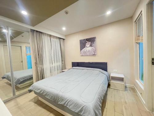 a bedroom with a large bed and a large window at Seven Seas Pattaya by nty in Jomtien Beach