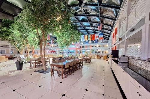 a restaurant with tables and chairs in a building at Travelodge by Wyndham Indianapolis Speedway in Indianapolis
