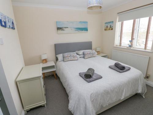 a bedroom with a bed with two towels on it at Sandy Bay House in Saundersfoot