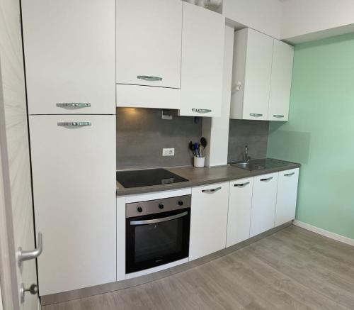 a kitchen with white cabinets and a stove top oven at Tiffany Suites Cesano 2 in Cesano Boscone