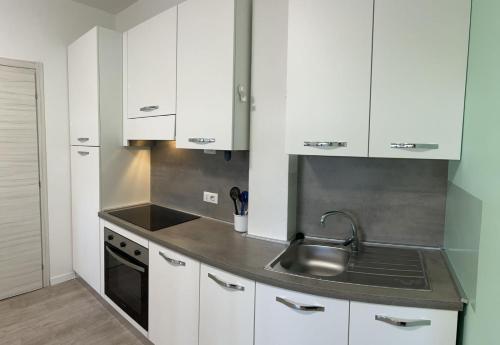 a kitchen with white cabinets and a sink at Tiffany Suites Cesano 2 in Cesano Boscone