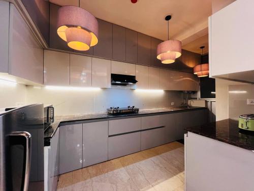 a kitchen with stainless steel cabinets and pendant lights at Villa Aqua WIth Swimming Pool in Lucknow