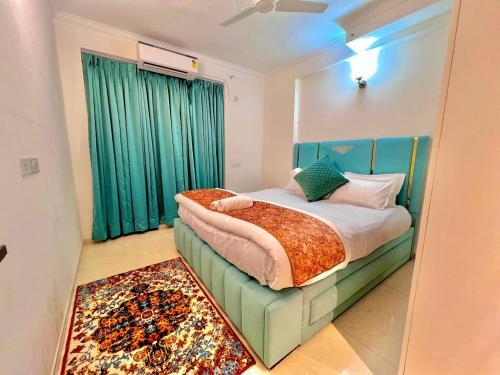 Schlafzimmer mit einem Bett mit grünen Vorhängen und einem Teppich in der Unterkunft Villa Aqua WIth Swimming Pool in Lucknow
