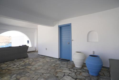 two blue and white vases in a room with a blue door at Onar Loutra, Kythnos in Loutrá