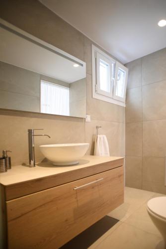 a bathroom with a bowl sink and a mirror at Onar Loutra, Kythnos in Loutrá