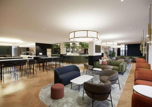 a lobby with tables and chairs and a bar at Doubletree By Hilton Sheffield City in Sheffield