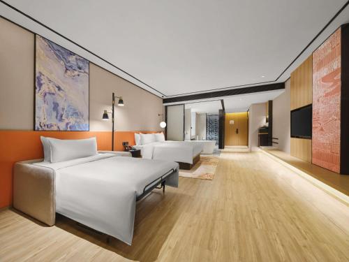 pokój hotelowy z 2 łóżkami i telewizorem z płaskim ekranem w obiekcie Hilton Garden Inn Jinzhong Yuci w mieście Jinzhong