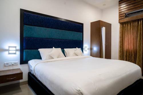 a large white bed in a hotel room at La Woods Village Resort in Tiruvannāmalai