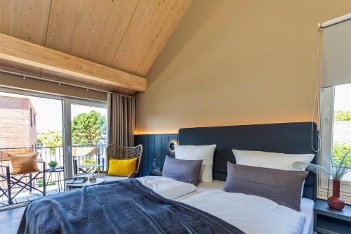a bedroom with a bed and a large window at Arthotel Bakker in Borkum
