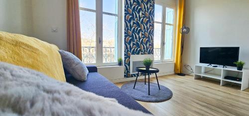 un salon avec un canapé bleu et une télévision dans l'établissement Le Chavanelle!, à Saint-Étienne