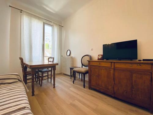 ein Wohnzimmer mit einem TV und einem Esstisch in der Unterkunft COROLLE Whole flat with garden near Paris in Vitry-sur-Seine