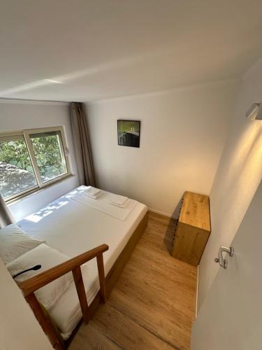 een kleine slaapkamer met een bed en een raam bij New Bazaar Studios in Tirana