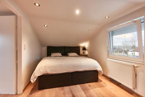 um quarto com uma cama grande e uma janela em Exclusive 3BD Chalét in Premium Location of Vienna w/ Sauna Swimming Pool Jaccuzi em Viena
