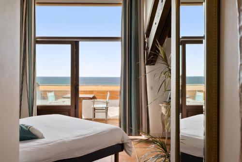 Un dormitorio con una cama y vista al mar. en La Maison Tamarin, en San Juan de Luz